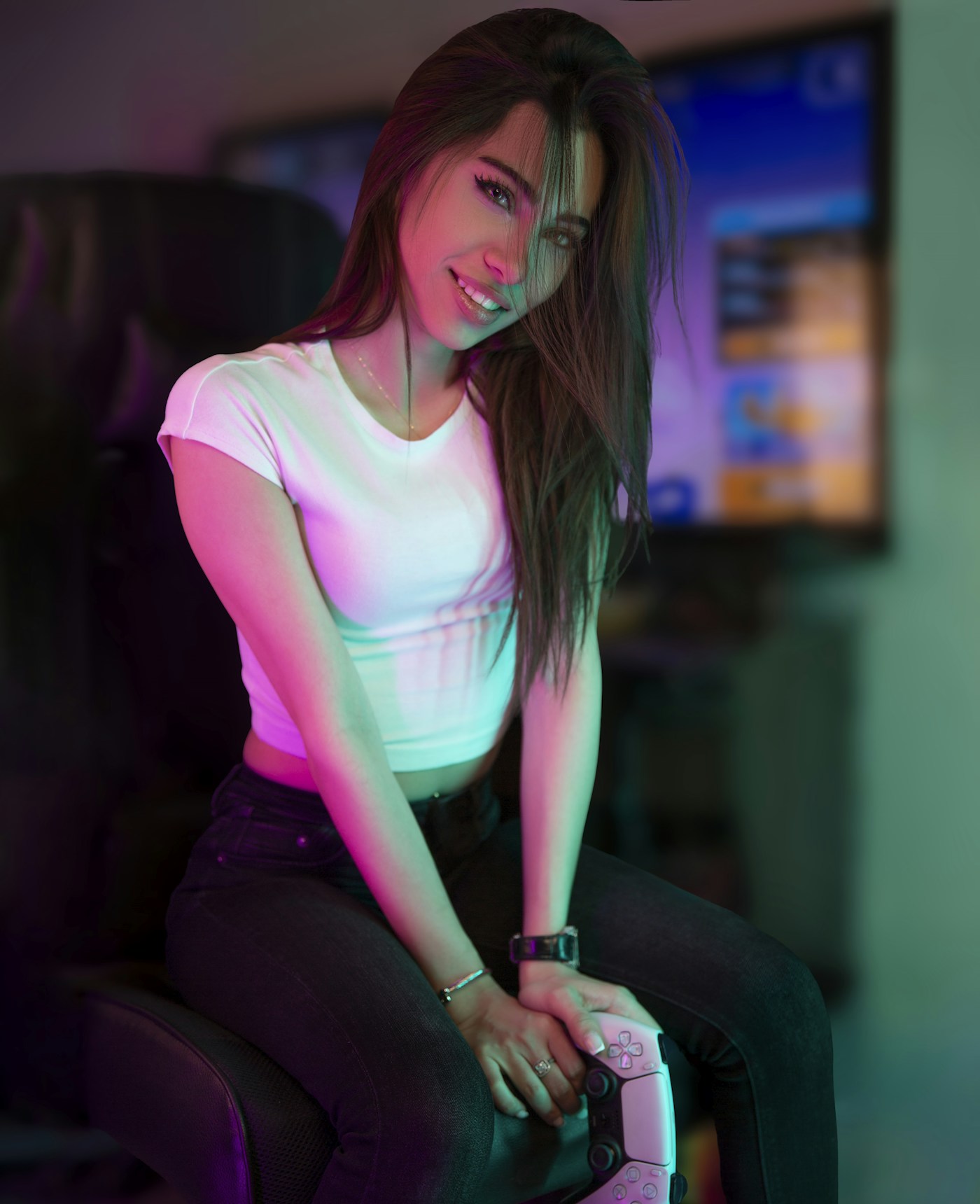 A gamer holding a controller in a colourfully lit room