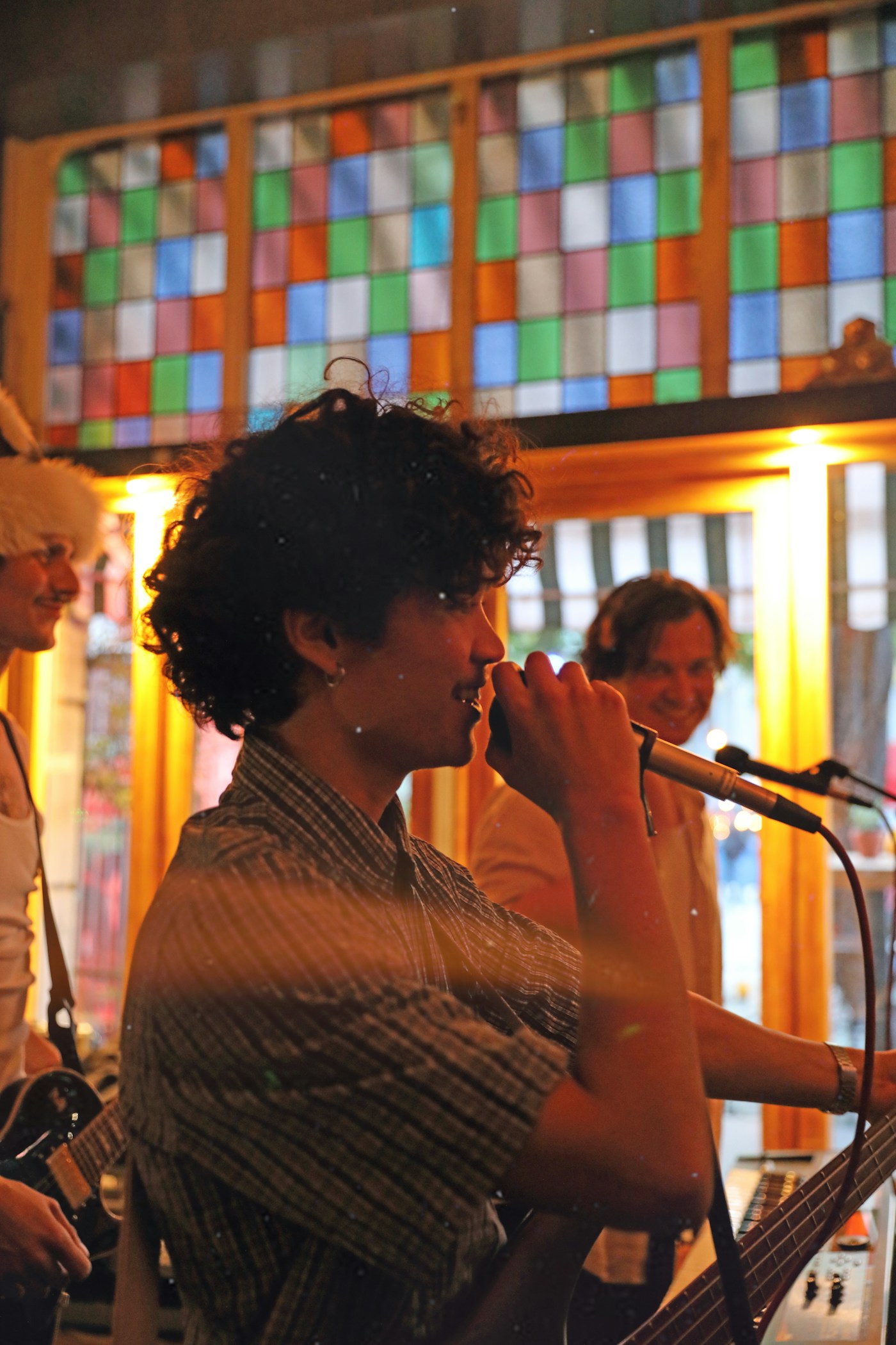 A musician singing into a microphone at an intimate live show